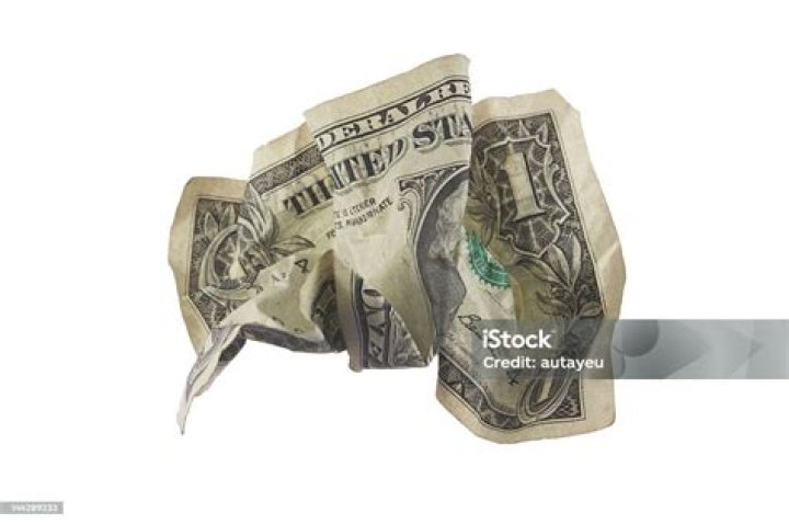  A bill is seen crumpled between a seat and a console in the car