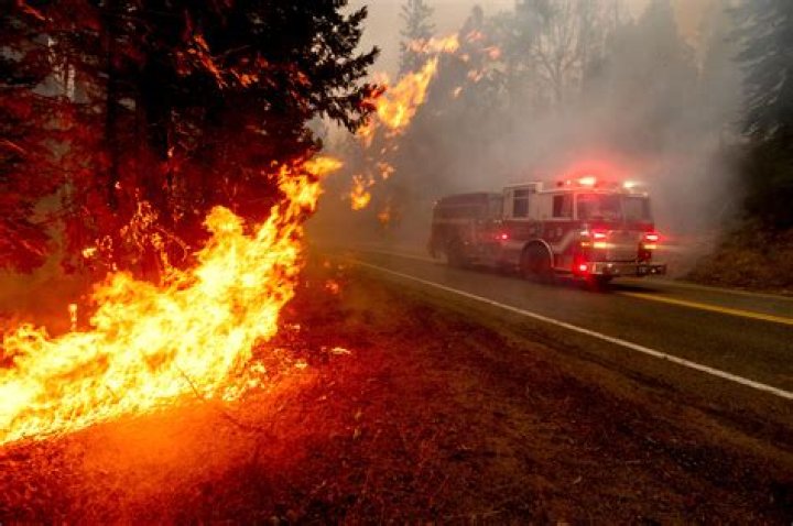 A firetruck drives along state Highway 168 while battling the Creek Fire
