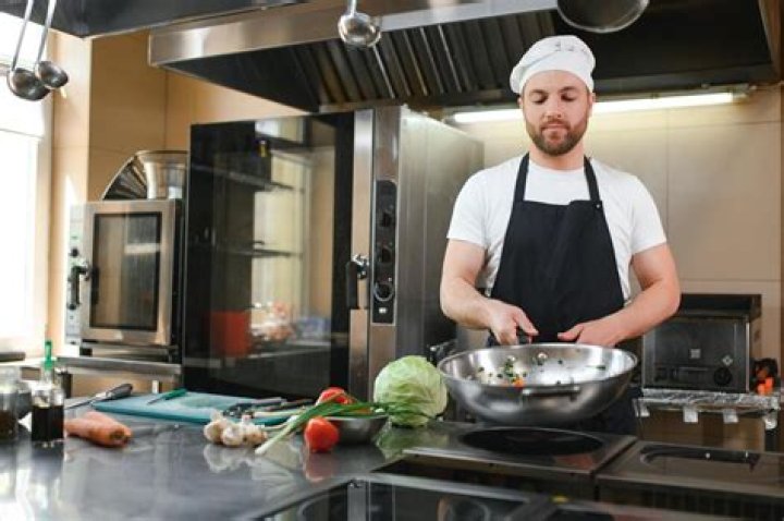  A kitchen worker uses a wooden mallet to hit a rat before it is killed to be cooked in a restaurant