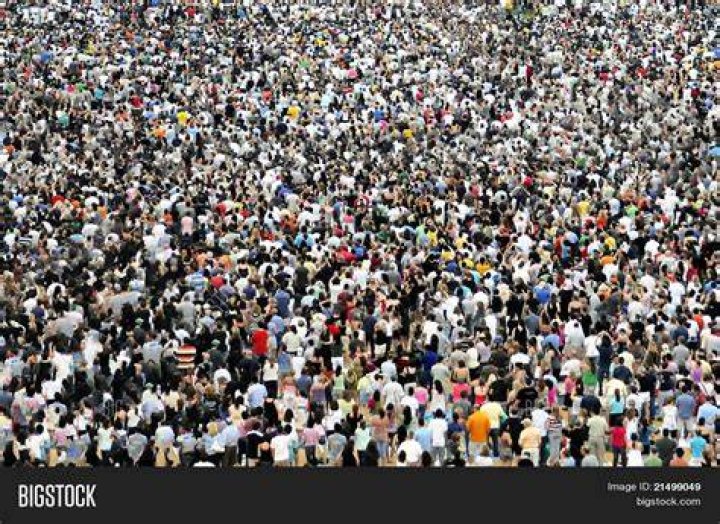 A large crowd of people participate in a party on a walkway near the beach, during spring break in Miami Beach, Florida