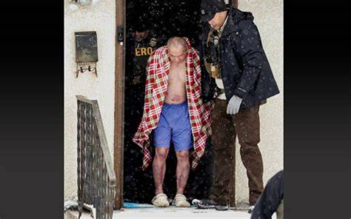  A shirtless man is dragged across the floor yelling