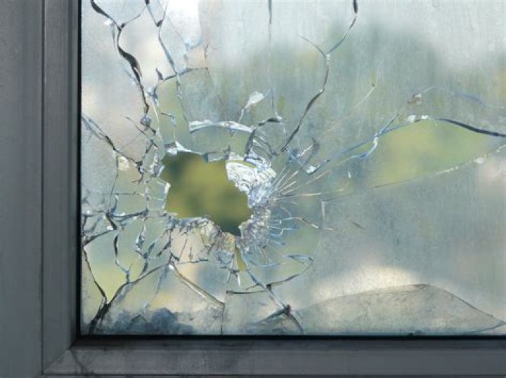 A smashed in window can be seen after the neighbor took to it with a sledgehammer