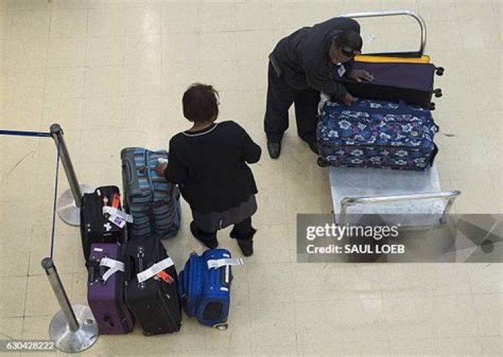 Baggage handlers at Ronald Reagan airport sort dozens of suitcases and bags