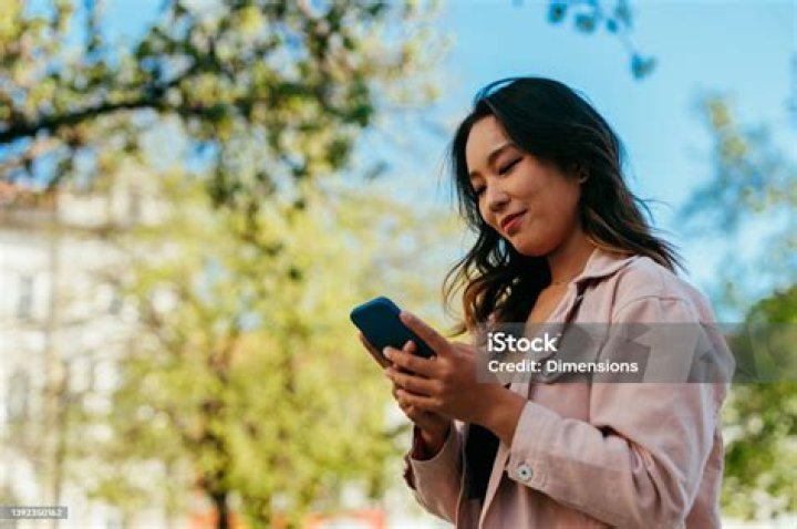 Beautiful young woman using phone in a downtown caf&eacute;