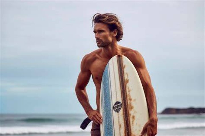 Bordeaux poses next to surfboards