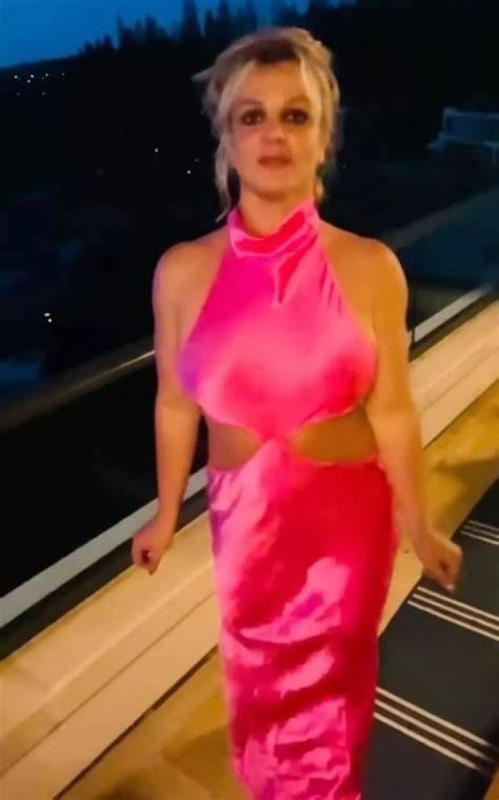 Britney Spears goes braless in a dangerously cutout dress for a sexy video in her Los Angeles home