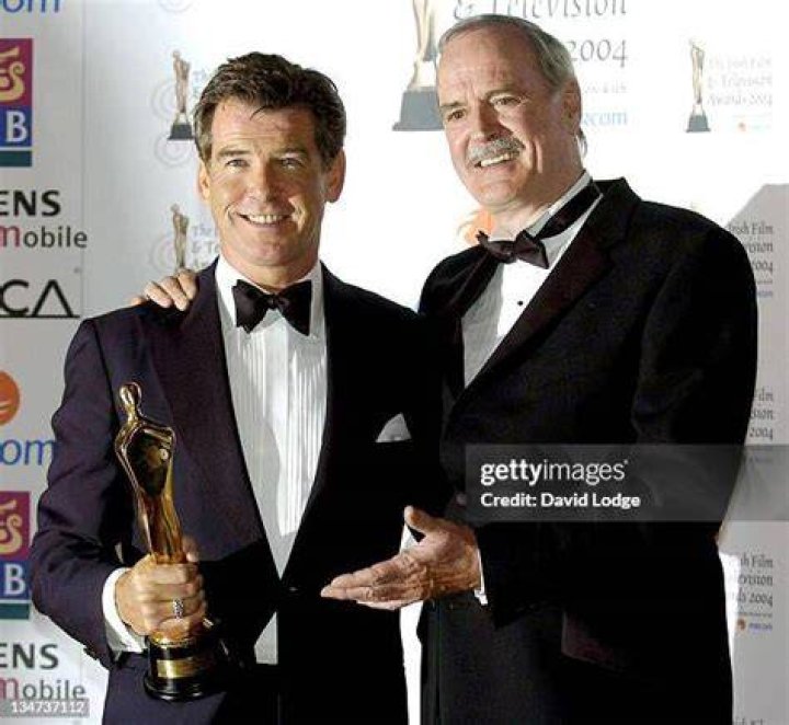 Brosnan alongside John Cleese and his Aston Martin Vanquish which turned invisible in Die Another Day (2002)