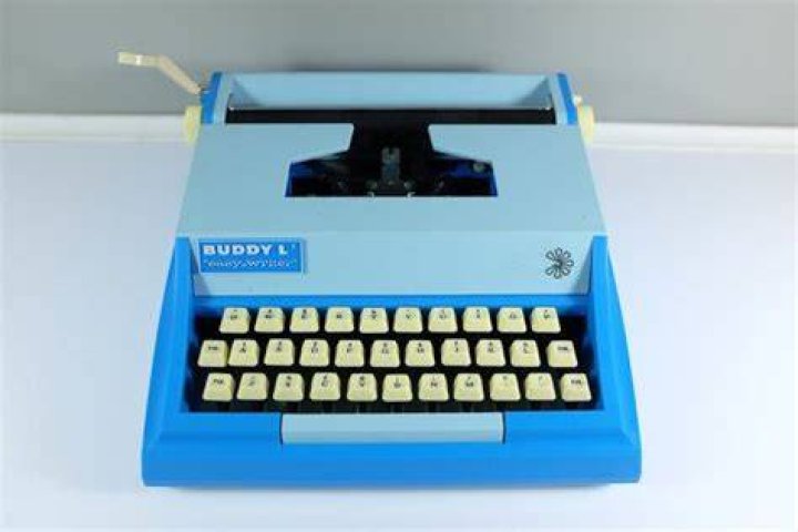 Buddy types on a typewriter sitting by an open fireplace