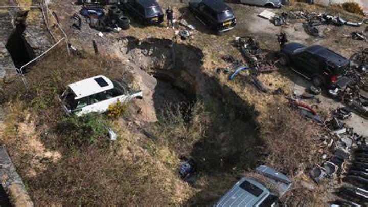 Cars went into a hole that was 20 feet deep, police said