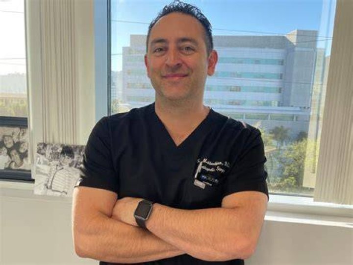 Doctor Shahab Mahboubian helps to stretch people's limbs at his clinic in California