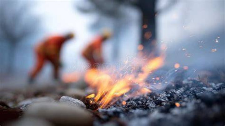 Firefighters rest in a smoldering forest in the Cascadel Woods