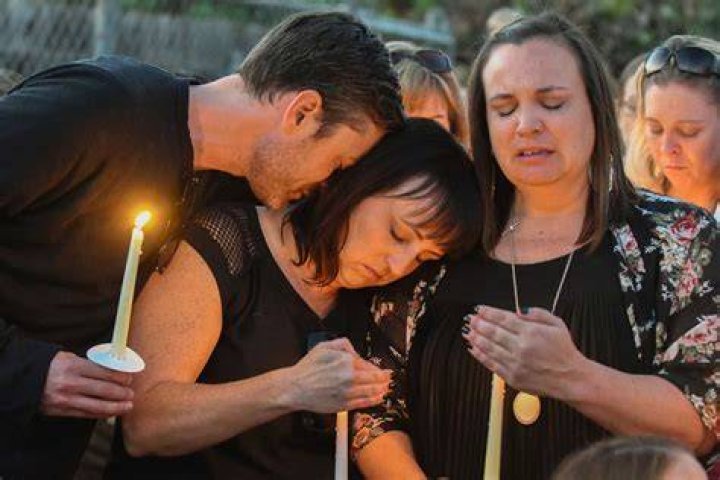 Friends of Teresa Nicol Kimura hug before a vigil on October 8, 2017