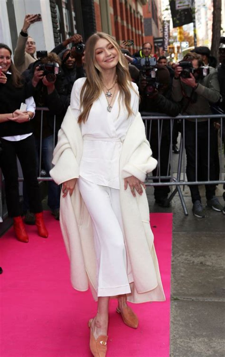 Gigi Hadid wore a simple ivory Prada gown with long black leather gloves