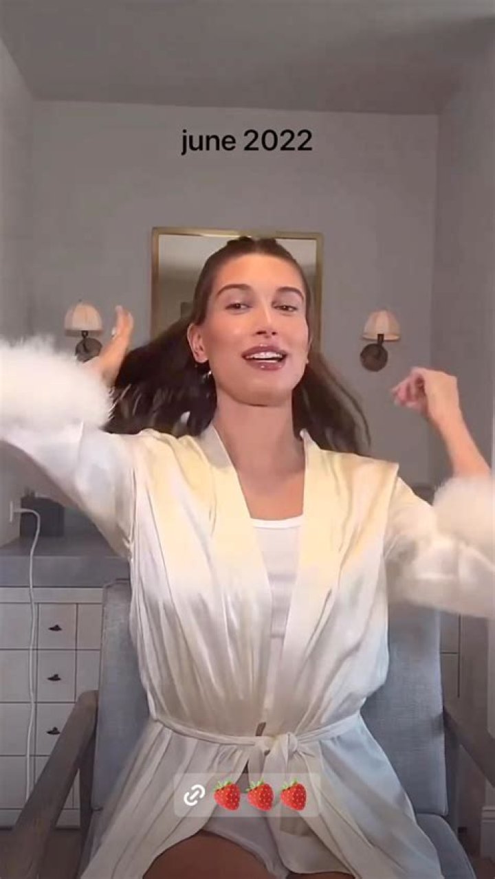 Hailey sported a white belted silk robe with fur at the end of the sleeves