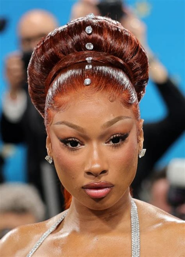 In the photos, Megan flaunted her wavy, powder-pink hair and glam makeup while showing off her cleavage in a low-cut sheer dress