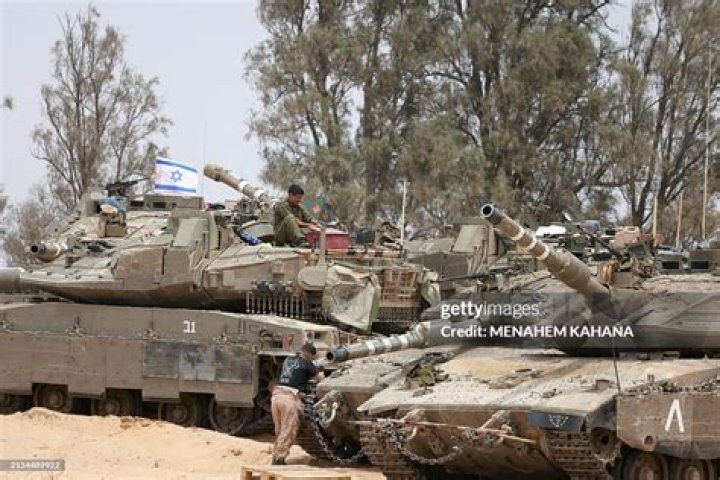 Israeli troops gather near an APC ahead of the raid