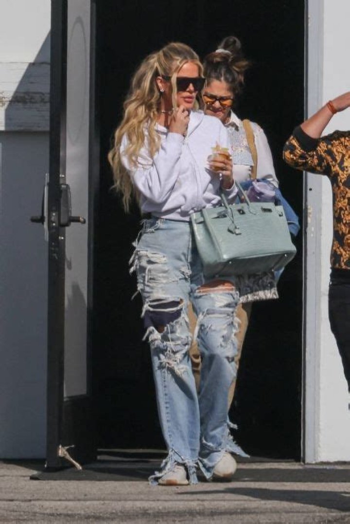 Khloe was seen carrying a matte alligator&nbsp;Birkin bag with gold hardware in a pretty seafoam green color that's priced at $125K