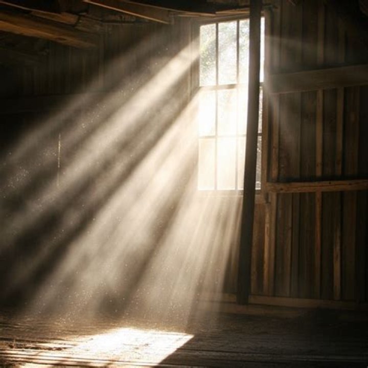 Lights streaming from the rustic farmhouse gives the venue a romantic touch