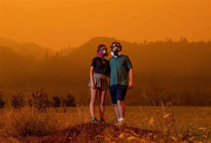 Mairead Milan and Alex Loznak stand in heavy smoke from wildfires near Elkton in rural Oregon