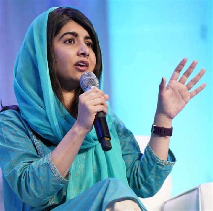  Malala Yousafzai laughs as she meets Prince Philip and he shakes her father's hand in 2013