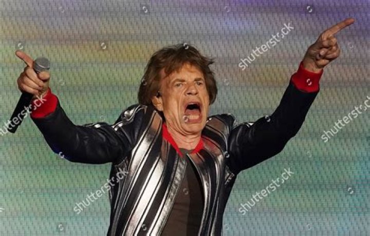 Mick's hand on his chest suggests he wants to be the centre of attention