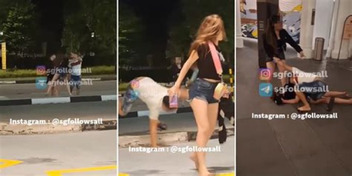  Onlookers intervene as a woman plunges her hands into another's hair