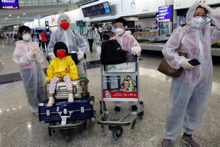  Passengers wear protective suits, amid the outbreak of coronavirus, at Hong Kong International Airport