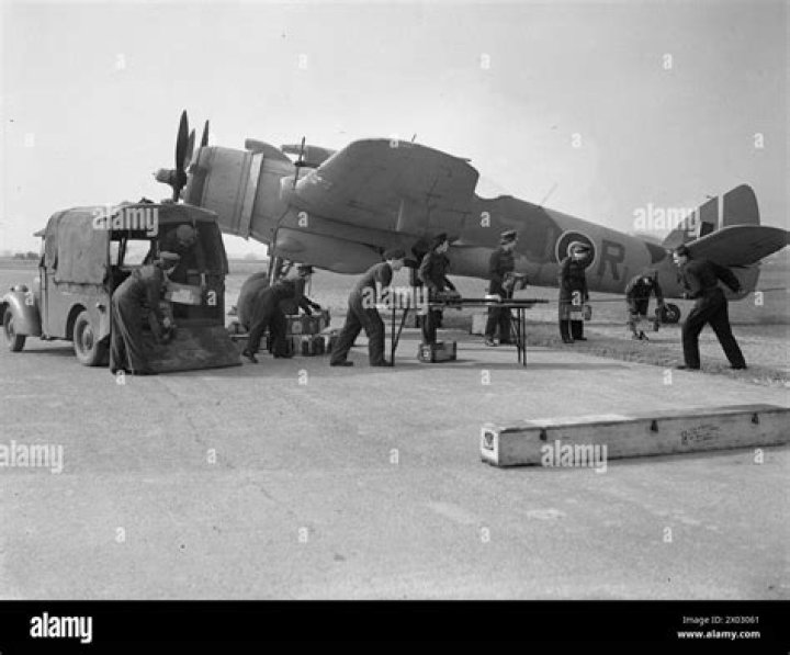  RAF armourers carrying 20mm cannon ammunition.