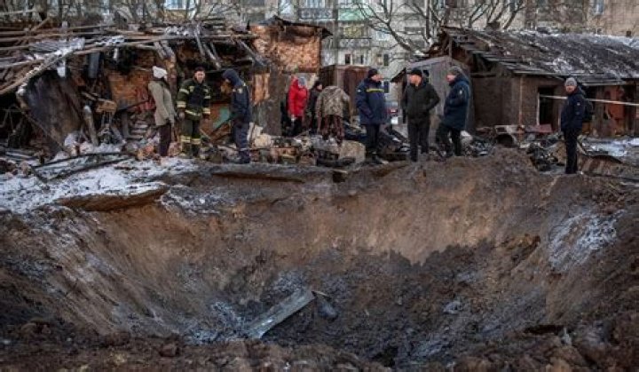 Residents look at a crater caused by a missile on the outskirts of Duhok, Iraq