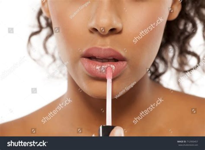 She applied the gloss on top of the lipstick as she achieved full pout perfection