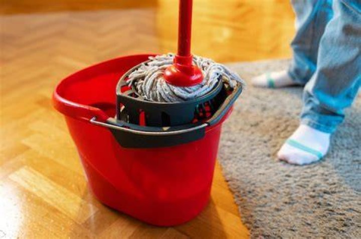 She dips her mop into a bucket of dish soap and hot water