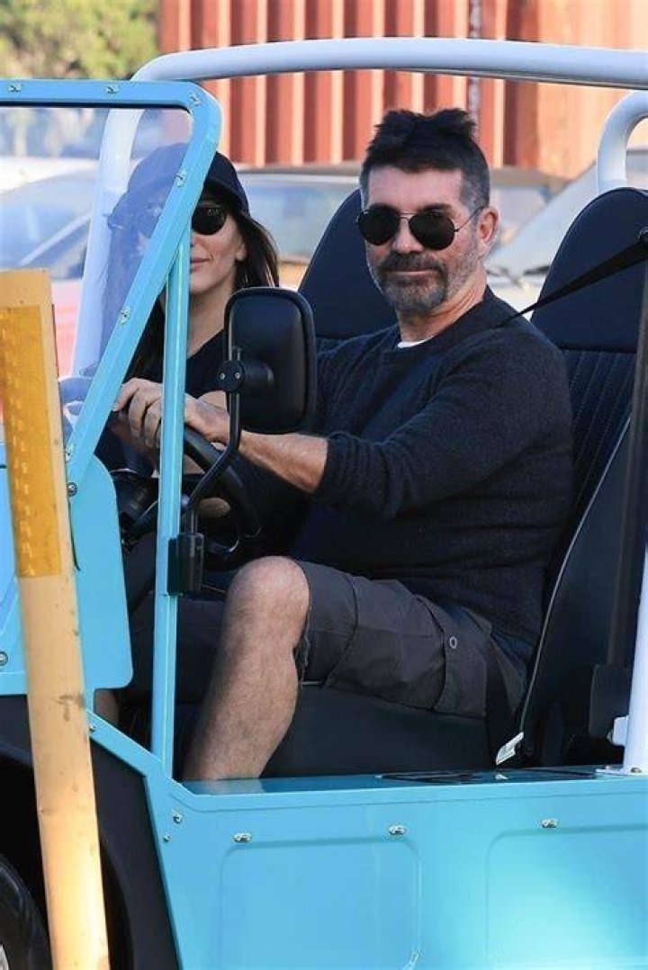 Simon strolls through Malibu with partner Lauren and the kids