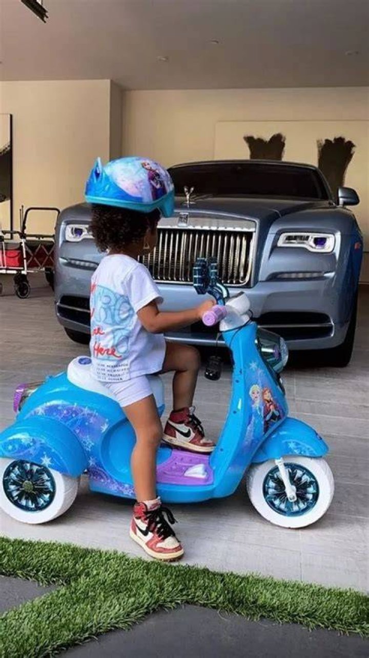 Stormi rides her scooter in Kanye's tee