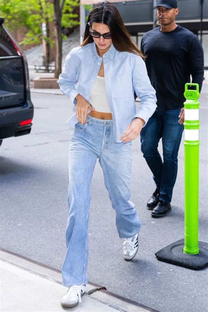 The model paired her jeans with a loose sweater and Adidas sneakers