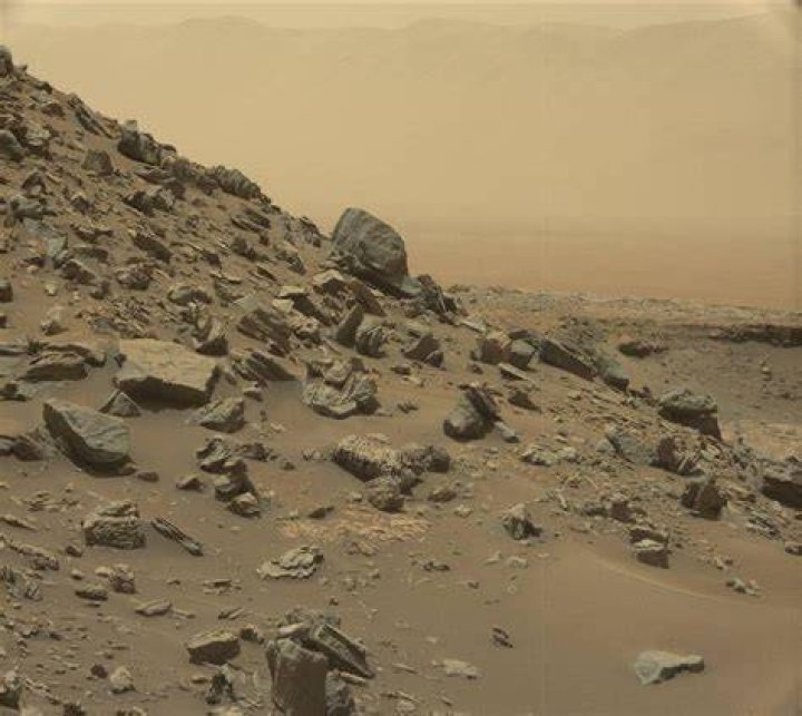 This Curiosity image shows sloping buttes and rocky, layered outcrops on Mount Sharp. The buttes are eroded remnants of ancient sandstone