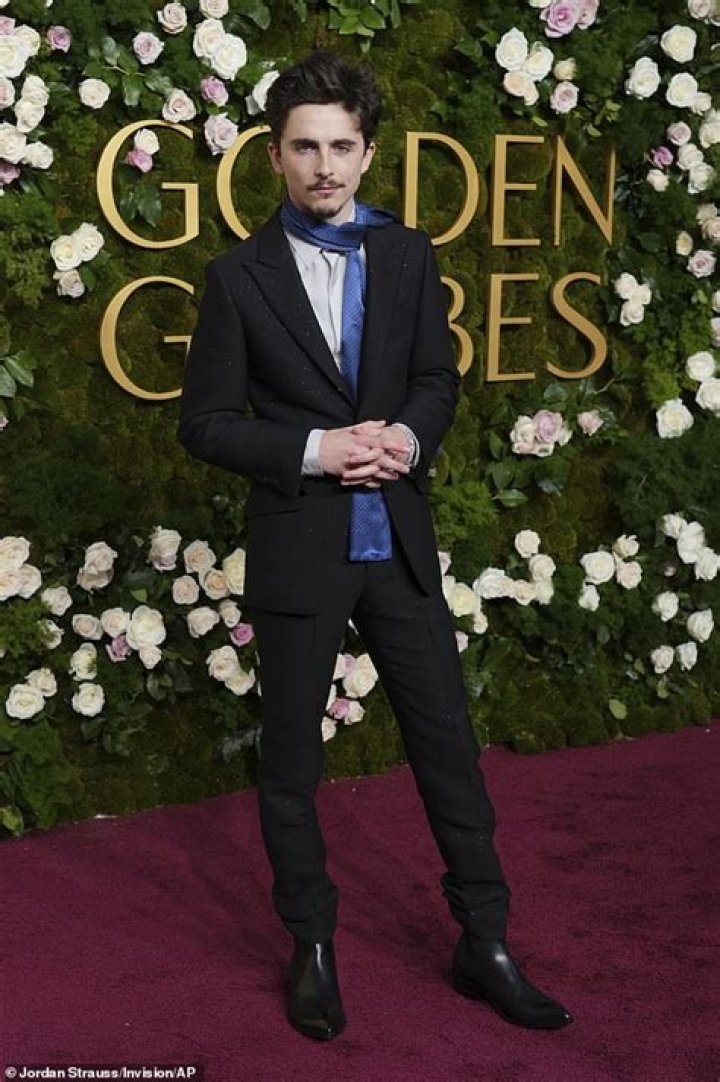 Timothee Chalamet posed in a pristine ivory suit and Cartier brooches with Converse shoes