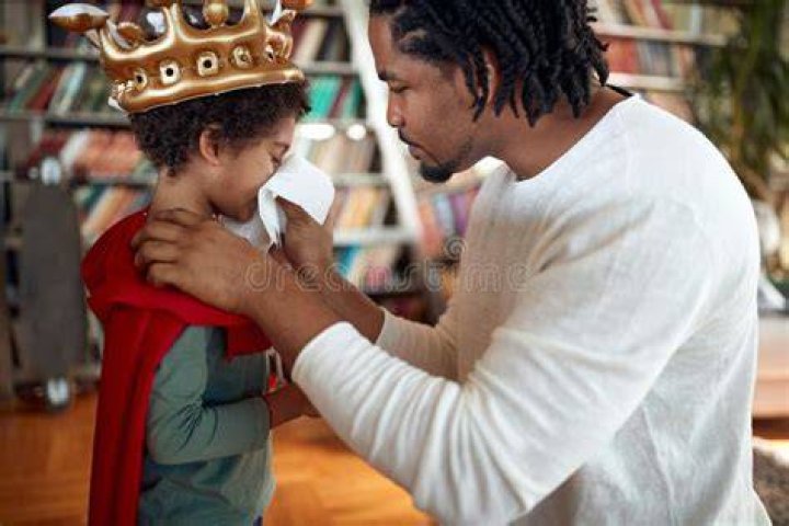 Toney helps his son blow out a candle on his birthday
