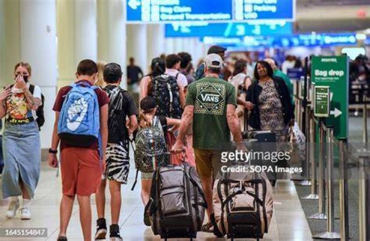 Travelers make their way through Miami airport as flight delays and cancelations sparked chaos across the country