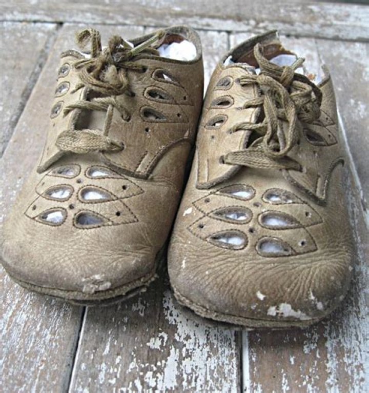 Vintage baby shoes have dirt on them