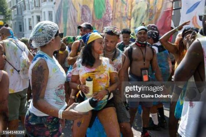 Weary party-goers take a few moments to rest on the street