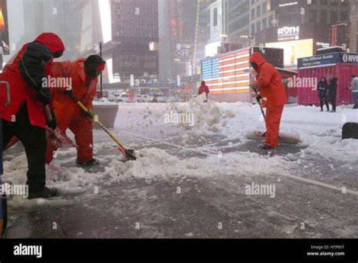 Workers shovel snow in Times Square as more severe weather arrives in Manhattan